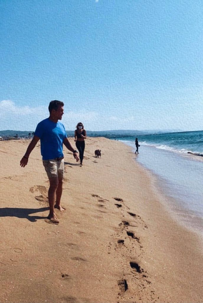 Casey, son épouse et leur chien marchant sur la plage  